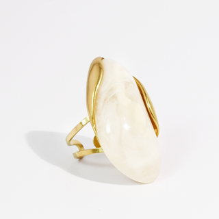 A gold wrap ring featuring a large, smooth, oval-shaped cream-colored stone.