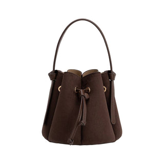 A recycled vegan suede bucket bag in a rich chocolate coloring, and a single top handle.