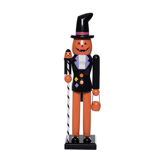 A painted wooden nutcracker-style Halloween figure with an orange pumpkin face, black hat and jacket, white shirt, orange pants, and small multicolor decorative accents, standing on a black base.