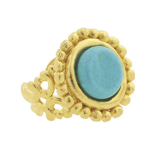 A gold ring featuring a large oval turquoise stone in a textured bezel setting, surrounded by a beaded border and an openwork scroll design on the band by Susan Shaw.
