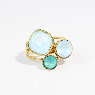 A gold ring featuring three round cabochon gemstones in light blue, pale aqua, and teal.