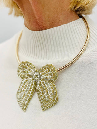 Necklace with a large, decorative bow pendant 