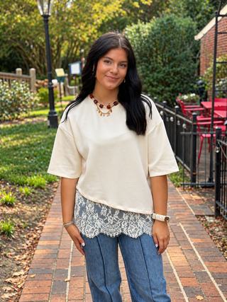 cream top with long asymmetrical lace hem