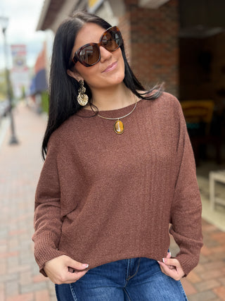A metallic shimmer knit top with a soft, lightweight feel, this easy piece features a wide boat neckline, long dolman sleeves, ribbed cuffs, and a relaxed draped silhouette