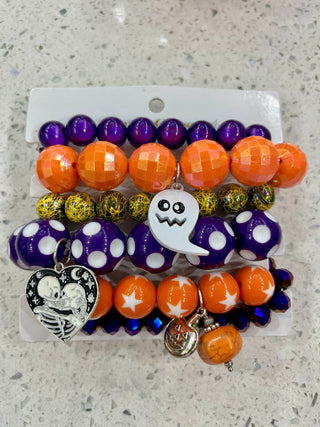A set of six Halloween-themed beaded bracelets featuring purple, orange, yellow, and white beads with a ghost charm and a skeleton heart charm.