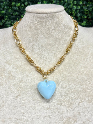 Gold chain necklace with a blue heart pendant.