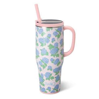 Floral-patterned mug with pink handle and straw.