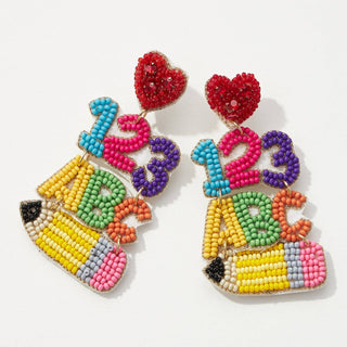 A pair of beaded drop earrings shaped like pencils with colorful beads forming the numbers 1, 2, and 3, the letters ABC, and red heart shapes at the top.