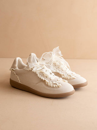 Cream colored retro style sneakers with lace detailing.