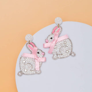 Decorative earrings with rabbit design and pink bows.