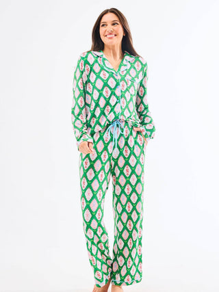 Woman wearing a green and pink nutcracker patterned pajama set 