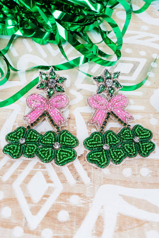 Pair of seed bead earrings with green clovers and pink bows.