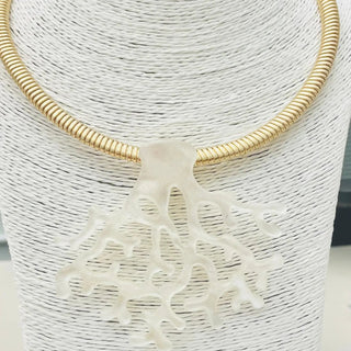 Gold necklace with a white coral-like pendant.
