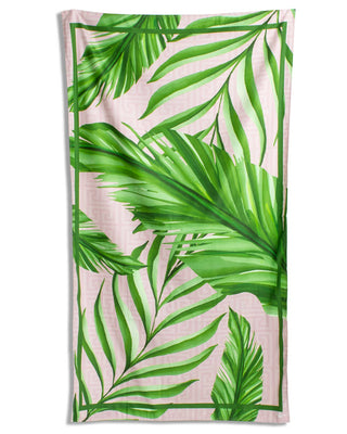 Beach towel with green palm leaf pattern.