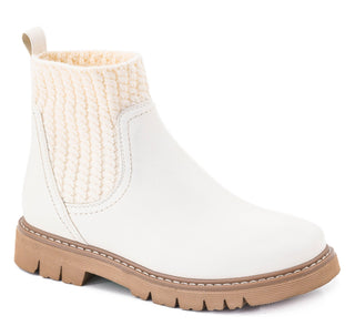 A white leather ankle boot with a cream-colored knit elastic side panel and a tan lug sole.