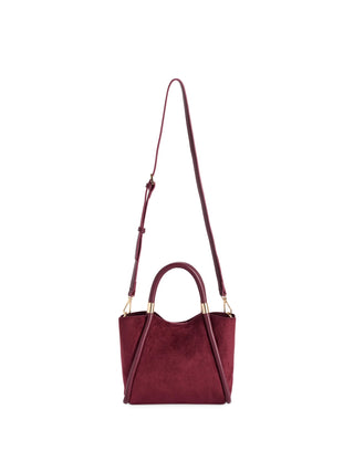A burgundy suede handbag with a top handle, a long shoulder strap, and gold-tone hardware.