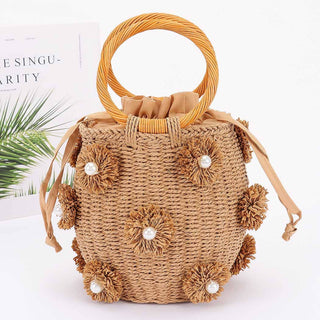 Woven handbag with floral and pearl embellishments.