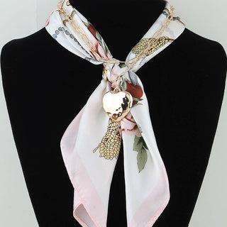 Scarf with floral design and gold heart pendant.