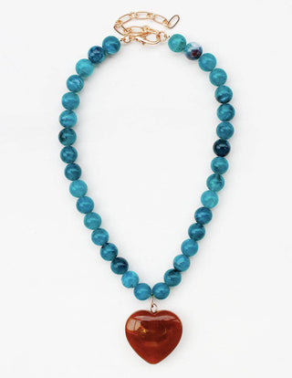 A beaded necklace featuring round turquoise-blue beads and a polished reddish-brown heart-shaped pendant, finished with a gold-tone clasp.