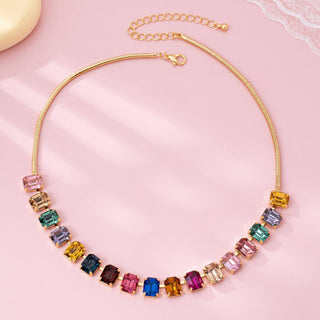 Statement necklace with multicolored gemstones on a gold chain.