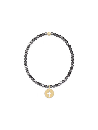 A stretch beaded bracelet made of small dark grey beads with a single gold-tone accent bead at the top and a circular gold-tone disc charm featuring a cutout cross design at the bottom.