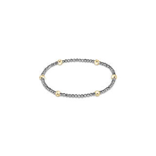 A stretch beaded bracelet featuring small faceted gunmetal hematite beads with evenly spaced larger 14K gold filled accent beads by Enewton.