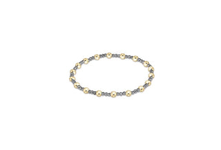 A stretch beaded bracelet featuring small faceted silver hematite beads alternating with larger polished gold round beads.
