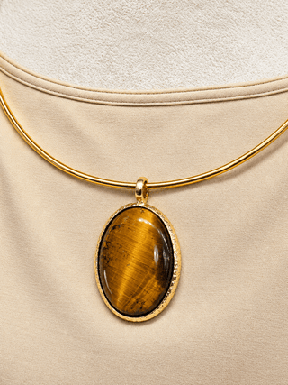 Gold necklace with a polished oval tortoise pendant.
