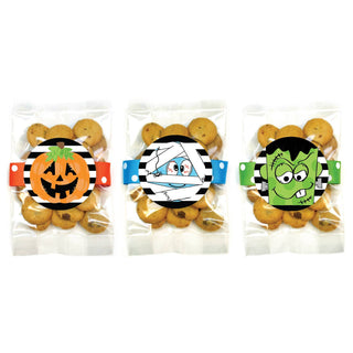 Three small clear bags of cookies decorated with Halloween-themed paper bands featuring a jack-o'-lantern, a mummy, and Frankenstein's monster.
