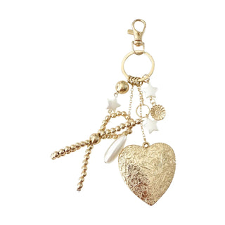 Gold heart-shaped bag charm with various charms 