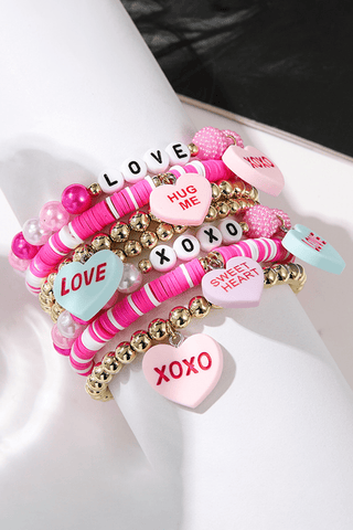 Collection of colorful bracelets with love-themed charms 