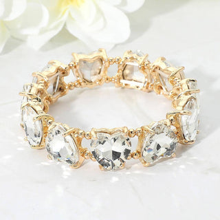 Gold bracelet with heart shaped clear gemstones.
