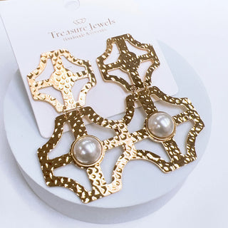 Gold earrings with pearl center stone.