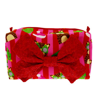 A rectangular zippered pouch or cosmetic bag with a festive Christmas gift wrap pattern featuring red and pink stripes, green trees, and leopard print, accented by a large red textured bow on the front.