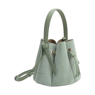 A sage green faux suede bucket bag with a top handle, drawstring closure, and a detachable shoulder strap.