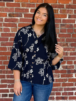 navy blue button blouse with embroidered white flowers and lace detail and smocked waist