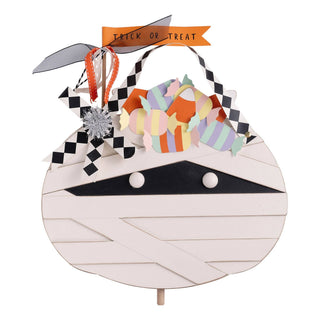 Halloween-themed topper shaped like a mummy with colorful candies and a 'Trick or Treat' banner.