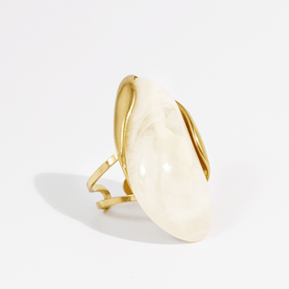 A gold wrap ring featuring a large, smooth, oval-shaped cream-colored stone.