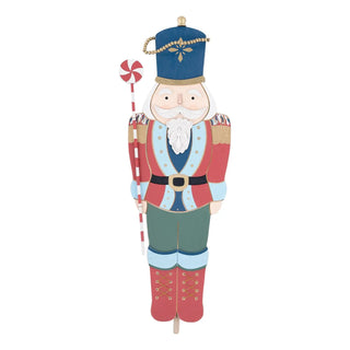 Decorative nutcracker topper with a blue hat and red outfit 