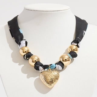 Scarf necklace with gold beads and a puffy textured heart-shaped pendant 