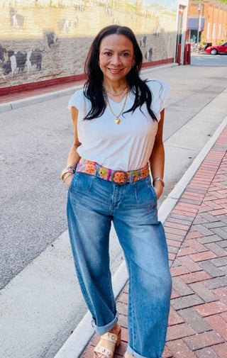 Woman wearing a white top and the barrel babe denim jeans.