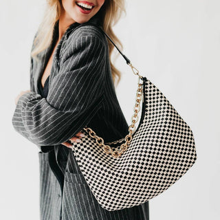 Black and white checkered handbag with a gold chain strap.