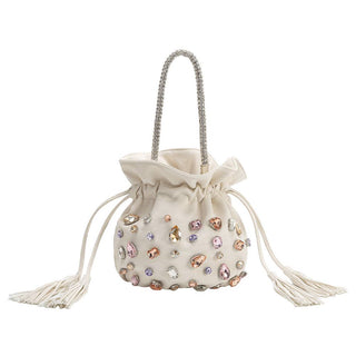 An off-white velvet drawstring bucket bag embellished with multicolored rhinestones and featuring a silver rhinestone-embellished top handle.