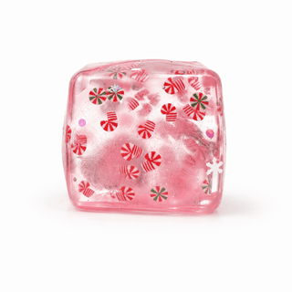 A translucent pink squishy ice cube containing embedded red and green striped candy peppermints.