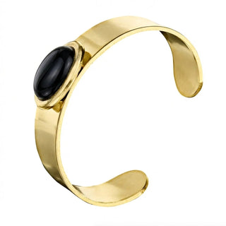 A wide high-polish gold-tone open cuff bracelet centered with a polished oval black onyx cabochon set in a smooth bezel.