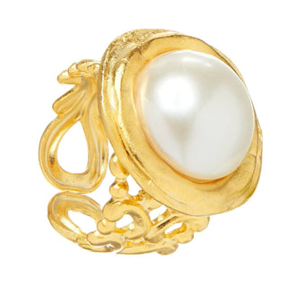 A gold ring featuring a large, round, lustrous white pearl set in an ornate, textured gold bezel with decorative scrollwork on the band by Susan Shaw.