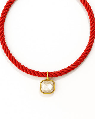 Red rope necklace with a gold pendant 