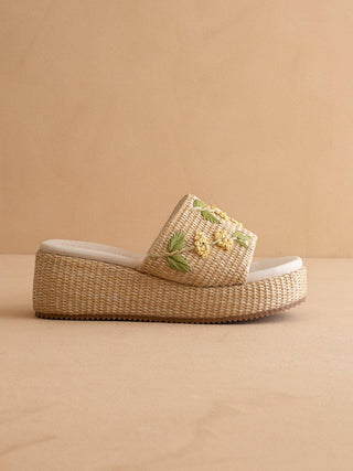 Woven sandal with floral embroidery.