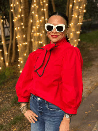 red Blouse, featuring a self-tie neckline, long puff sleeves, and green scalloped contrast trim