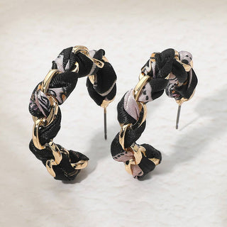 Pair of braided hoop earrings with black, gold, and pink 